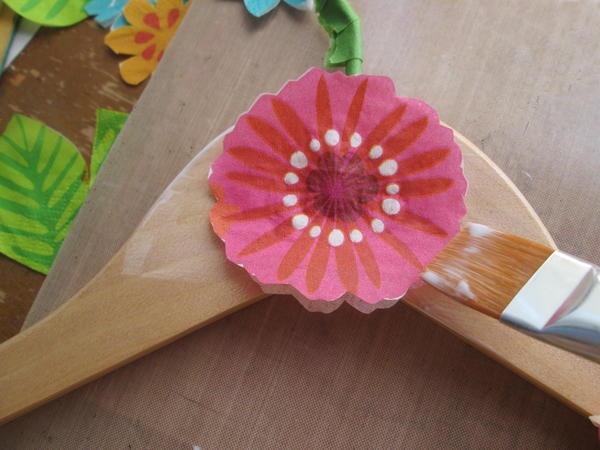 Working quickly, pick up the flower with the brush and place carefully onto the glued section of the hanger. Working quickly, pick up the flower with the brush and place carefully onto the glued section of the hanger.